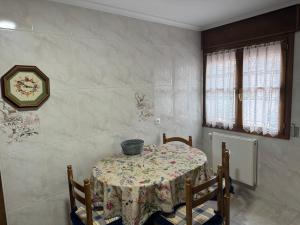 una mesa de comedor con un jarrón encima en Camín de la plaza, en Carreña