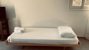a bed with white sheets and two towels on it at 1 Bed-3 Guests-Pets-Private terrace-Sea Views in Agios Ioannis Tinos