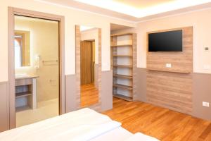 a bedroom with a tv on a wall at Sporthotel Olimpo in Garda
