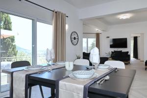 a dining room with a table and a living room at Villa Mirage Skopelos in Skopelos Town
