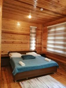 シェキにあるNarin Qala Resortの木製の部屋にベッド1台が備わるベッドルーム1室があります。