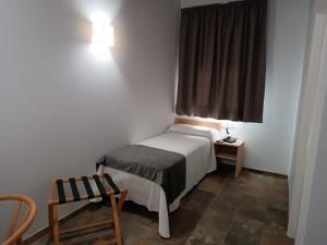 a small bedroom with a bed and a window at Hospedería La Cilla in La Puebla de Cazalla