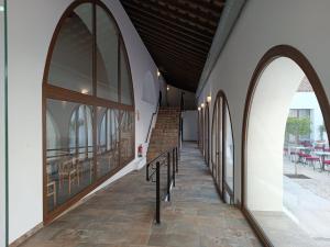 a hallway with arched windows and stairs in a building at Hospedería La Cilla in La Puebla de Cazalla