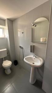 a bathroom with a sink and a toilet and a mirror at Forest house in Eforie Nord