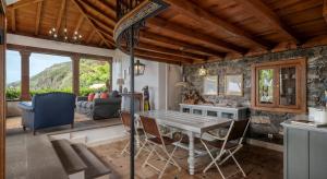a kitchen and living room with a table and chairs at OurMadeira - Villa do Mar I, secluded in Arco da Calheta