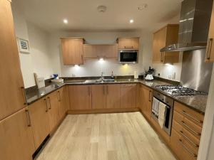 eine Küche mit Holzschränken und einem Herd mit Backofen in der Unterkunft 30 Bredon Court Newquay Sea view in Newquay + 16 Fotos