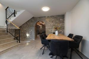 a dining room with a stone wall and a table and chairs at Villa Angelica in Lakmartin