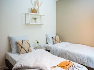 two beds in a room with white walls at Calming Hideaway in Veluwe in Voorthuizen +31 photos