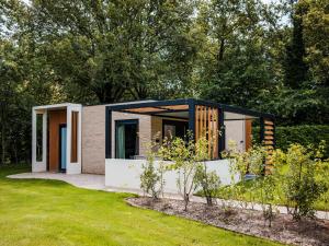 a small house in a garden with trees at Calming Hideaway in Veluwe in Voorthuizen