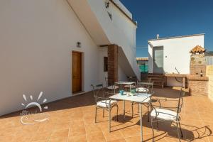 a patio with chairs and a table and a building at Apartamento LUZ E in Bolonia