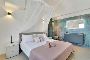 a bedroom with a bed and a flat screen tv at Las Dunas with Stunning Sea View and Shared Pool in Kralendijk
