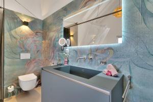 a bathroom with a sink and a colorful wall at Las Dunas with Stunning Sea View and Shared Pool in Kralendijk +45 photos