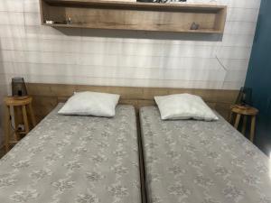 a bed with two pillows on it in a room at Camping de Bernadou - Le Lodge in Villemur-sur-Tarn
