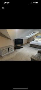 a bedroom with a bed and a tv in a room at Cherry Blossom lodge deluxe loft in Marton
