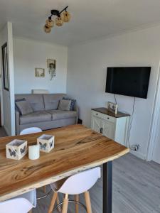 ein Wohnzimmer mit einem Tisch und einem Sofa in der Unterkunft Villers vue sur mer in Villers-sur-Mer