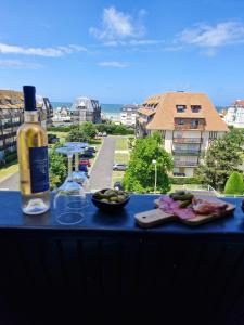 eine Flasche Wein und ein Teller mit Essen auf dem Tisch in der Unterkunft Villers vue sur mer in Villers-sur-Mer + 3 Fotos