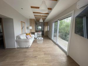 Ionian home في Exanthia: غرفة معيشة مع أريكة ونافذة كبيرة +صورة واحدة