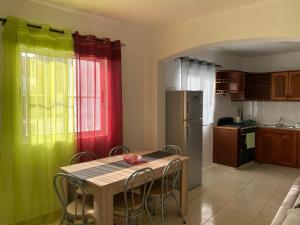 a kitchen with green and red curtains and a table with chairs at Katila Morro Coral in Espargos