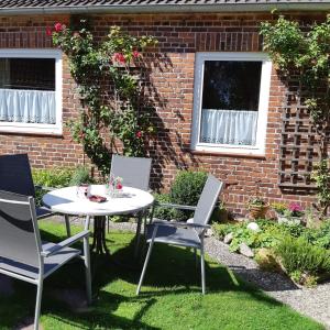 a table and chairs in front of a brick building at Nordseeferienhaus Peter in Niebüll +14 photos
