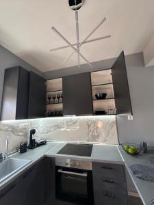 a kitchen with black cabinets and a sink at Asteris luxury house in Polygryos