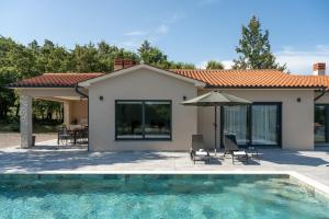 a villa with a swimming pool and a house at Villa Photinia in Labin