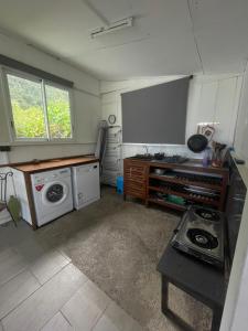 a kitchen with a stove and a washing machine at L'Écrin de Langevin in Saint-Joseph