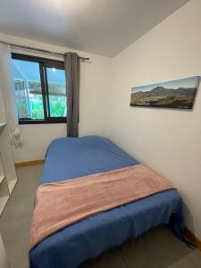 a small bedroom with a bed with a window at L'Écrin de Langevin in Saint-Joseph +3 photos
