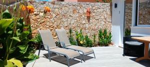 two chairs on a patio with a stone wall at Dona Ana Guesthouse in Lagos