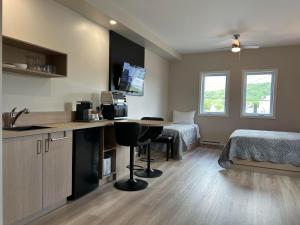 a room with a bed and a kitchen with a table at Hôtel St-Michel in Saint-Michel-des-Saints