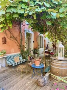 a patio with a table and chairs and a tree at chambre d hôte de charme Ste Cécile les vignes in Sainte-Cécile-les-Vignes