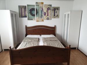 a bed in a bedroom with paintings on the wall at Rozmaring Vendégház in Szeged