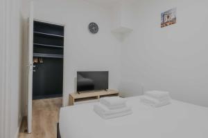 a white room with a bed and a television at Modern Apartment - 2BR-6P- Levallois-Perret in Levallois-Perret