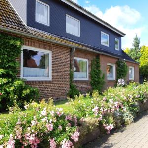 a house with flowers in front of it at Nordseeferienhaus-Alma in Niebüll
