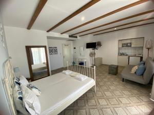a living room with a white bed and a couch at KLIO Apartments and Studios in Nei Poroi