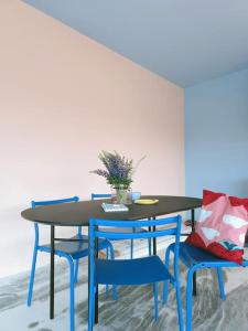 a dining room table with blue chairs and a table at Huoneisto Sipoossa in Helsinki