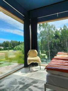 a chair sitting in a room with a large window at Huoneisto Sipoossa in Helsinki