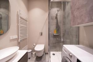 une salle de bain avec une douche, des toilettes et un lavabo dans l'établissement Cosy Old Town flat in a modern secured apt. block, à Riga 21 autres photos