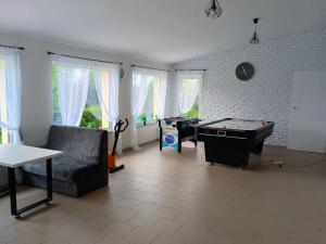 a living room with a couch and a pool table at W zieleni in Polanica-Zdrój