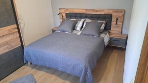 a bedroom with a large bed with a wooden headboard at Stone House Josipa in Ražanj +16 photos