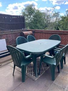 a green table and chairs on a patio at Home in London, N14 nearby Trent Park and Alexandra Palace in East Barnet