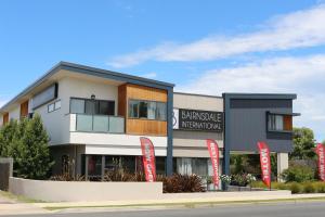 a building with red signs in front of it at Bairnsdale International in Bairnsdale