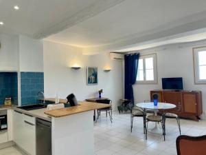 a kitchen and dining room with a table and chairs at Palais Hongran de Fiana in Nice