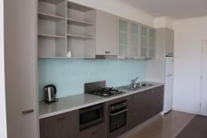 a kitchen with white cabinets and a stove top oven at Bairnsdale International in Bairnsdale