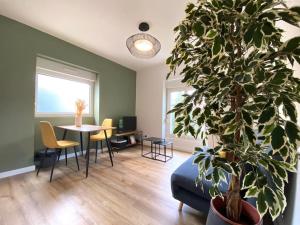 a living room with a table and a potted plant at Appartements avenue général Leclerc in Vienne