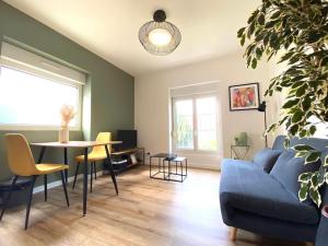 a living room with a blue couch and a table at Appartements avenue général Leclerc in Vienne +9 photos