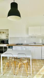 a white kitchen with a white table and chairs at Ile de Malvy in Saint-Simeux +51 photos