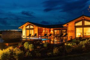 a log home with a pool and patio at night at Roubenka Smetanka in Smetanova Lhota