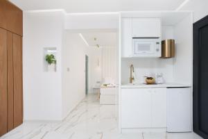 a white kitchen with white cabinets and a microwave at Mona Lisa in Pefkohori
