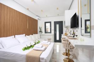 a white living room with a large bed and a table at Mona Lisa in Pefkohori