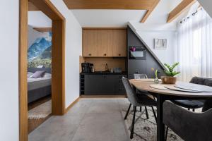a kitchen and dining room with a table and a bed at Księżycowe Apartamenty SPA by Golden Villas in Zakopane